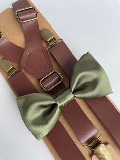 "This trendy and stylish bow tie and suspenders set is great for so many occasions! Bow tie made of silky satin fabric with a matching, adjustable neck strap.  Suspenders are made from faux eco leather.  All our bow ties can be made in the following sizes, just specify which size you need in a note at checkout:  Sizes: Kids (2-6y) 4\" x 2\" Youth (7-12 y): 4.5\" x 2.25 Adult (13 y and older) 5\" x 2.5\" All our bow ties are made by hand; therefore, measurements are a guideline only and cannot be Emerald Green Brown Suspenders, Bow Tie Ring, Tie Ring, Rustic Boho Wedding, Bearer Outfit, Ring Bearer Outfit, Leather Suspenders, Suspenders Set, Boys Bow Ties