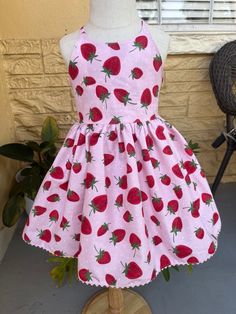 Picking strawberries with your little ones is a perfect occasion to wear this beautiful strawberry dress handmade in woven cotton fabric with elastic at the waist in the back for better for the comfort of your little one This beautiful dress is perfect for a Strawberry theme party or any occasion   *The dress in the sample photograph has a pettyskirt underneath, to give volume and fullness of the skirt to the dress.  *The petty skirt is not included *Orders ship in approximately 7 business days. If you need your order sooner, ask about a rate for expedited shipping. Cute Pink Cotton Sundress, Cute Cotton Dress For Garden Party, Playful Red Dress For Garden Party, Sweet Sleeveless Cotton Dress, Pink Cotton Twirl Dress For Garden Party, Cute Red Dress For Garden Party, Handmade Fitted Pink Dress, Cute Handmade Sleeveless Dress, Cute Cotton Twirl Dress For Garden Party