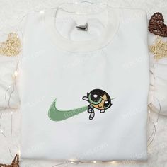 Buttercup x Green Nike Swoosh Embroidered Shirt, Powerpuff Girls Cartoon Embroidered Hoodie, Best Gift Ideas For Girls Welcome to Tinicloset, where we transform clothing into an exciting canvas of cool and cute creativity! Our store is a haven for those seeking to express their unique style with a touch of nostalgia. At Tinicloset, we specialize in crafting custom embroidered shirts, sweatshirts, T-shirts, and hoodies that transcend mere fashion to become cherished pieces of wearable art. We are Sporty Cotton Sweatshirt With Character Print, Sporty Cotton Sweatshirt With Cartoon Print, White Sporty Sweatshirt With Cartoon Print, Transform Clothes, Powerpuff Girls Cartoon, Embroidered Shirts, Best Gift Ideas, Girls Cartoon, Nike Swoosh