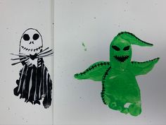 two children's handprints of halloween characters, one in green and the other in black