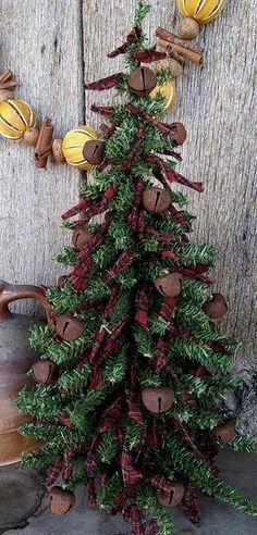 a christmas tree made out of wood with ornaments around it on the side of a wooden wall