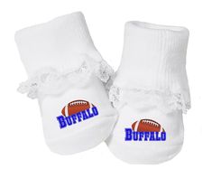 a pair of white baby shoes with the word buffalo on it and an american football