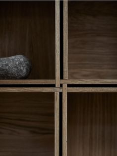 a rock sitting on top of a wooden shelf next to some shelves filled with books