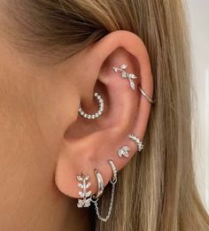 a woman's ear with three different piercings