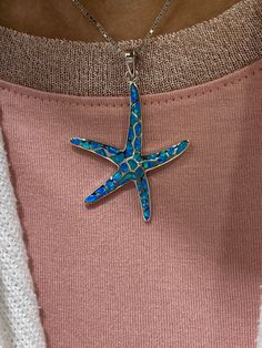 Embark on a Florida Keys tropical adventure with this eye-catching pendant necklace. Starfish have quite a few meanings and connotations attached to them but many times they represent renewal and regeneration. Starfish are also well known to represent infinite and divine love. According to legend, starfish are reflections of stars in the sky that inhibit the ocean floor symbolizing rebirth and longevity. This piece is crafted in real 925 sterling silver and inlaid with iridescent blue opal gemst Blue Starfish Charm Necklace, Ocean-inspired Blue Jewelry With Star Charm, Unique Starfish Jewelry As A Gift, Blue Sterling Silver Necklace With Starfish Charm, Blue Sterling Silver Necklaces With Starfish Charm, Blue Star-shaped Nickel-free Necklace, Blue Necklaces With Starfish Charm For Gifts, Blue Starfish Sterling Silver Necklace, Blue Sterling Silver Starfish Necklace