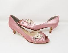 Dusty Rose Wedding Shoes with a comfortable kitten heel. These elegant pink/rose kitten heels are a comfortable choice as your Bridal Shoes. Adorned with a sparkling crystal and pearl bow design.FEATURES: Kitten heel ( 1 3/4 inches) Satin upper Leather Sole Peep toe Sparkling Crystals Creamy faux pearls Designed in the USA If you would like the shoes dyed a color from my color chart, please leave the dye color you would like in the TEXT BOX. If you would like to send me a swatch to color match p Pink Wedding Shoes With 4-inch Heel, Fitted Pink Wedding Shoes With Round Toe, Spring Wedding Kitten Heels With Almond Toe, Spring Wedding Almond Toe Kitten Heels, Fitted Pink Wedding Shoes For Spring, Pink 4-inch Heel Wedding Shoes, Formal Pink Closed Toe Wedding Shoes, Feminine Pink Kitten Heels For Formal Occasions, Elegant Pink Wedding Shoes