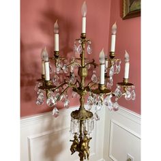 a chandelier hanging from the side of a wall in a room with pink walls