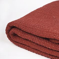 a stack of red blankets folded on top of each other in front of a white background