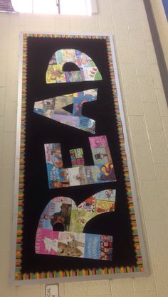 the number three is made out of magazines and newspaper strips on a bulletin board in a school hallway