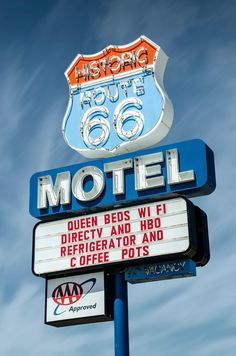 a motel sign with the words historic route 66 on it's side and an old neon sign above it