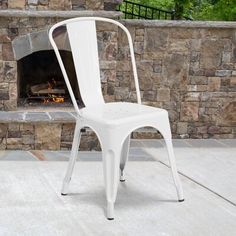 a metal chair sitting in front of a fire place