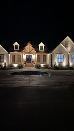 a large house lit up at night with lights on the front and side of it