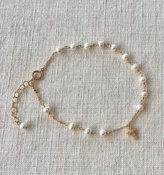 This is a dainty fresh pearl rosary chain bracelet. This minimalist chain bracelet is made of Natural fresh pearl wire wrapped in gold filled. It is fine and delicate, very feminine and elegant, beautiful. I use 4mm natural fresh pearl.   All components are gold filled. Fresh pearl and Gold are the best combination. This bracelet is 6.5", but there's a length adjustable chain for generous use.  You can mix and match this bracelet with other jewelry. Pearl Gold Chain, Minimalist Chain, Pearl Rosary, Rosary Bracelet, Rosary Chain, June Birthstone, June Birth Stone, Pearl Bracelet, Rosary