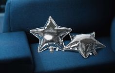 two shiny silver stars sitting on top of a blue chair