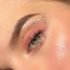 a woman with glitter on her eyes and lashes is looking at the camera while she's wearing pink eyeliners