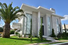 a white house with palm trees in the front yard and stairs leading up to it