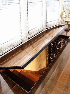 a wooden table with wine bottles in it on top of a hard wood flooring area