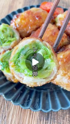 some food on a blue plate with chopsticks in it and an appetizer