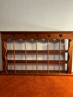 a wooden shelf with hearts on the top and two shelves below it that are made out of wood