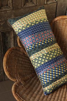 a woven pillow sitting on top of a wicker chair