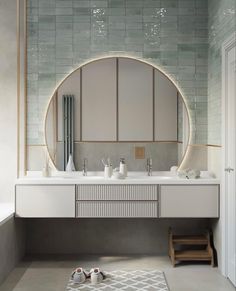 a bathroom with a round mirror above the sink and two white shoes on the floor