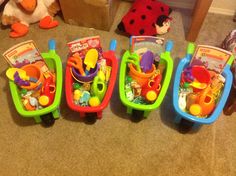 five toy cars lined up next to each other on the floor with stuffed animals in them