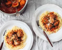 three plates of spaghetti with meat and tomato sauce on the side, next to a pot of pasta