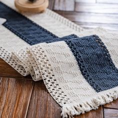 a close up of a rug on the floor with a wooden object in the background