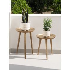 two small wooden tables with plants on them