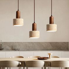 a dining room table with four hanging lights above it