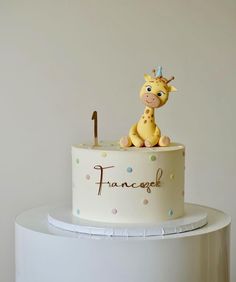 a cake with a giraffe on top and the number 1 is for someone's first birthday