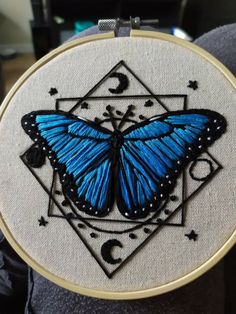 a blue butterfly sitting on top of a piece of fabric