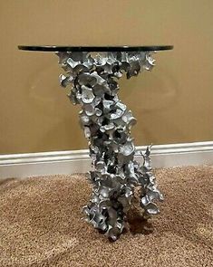 a table that has been made out of metal flowers on it and is in the middle of a carpeted room