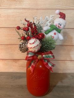 a red mason jar filled with christmas decorations