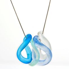 two blue and white necklaces hanging from a string on a white background with an object in the foreground