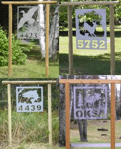 four different metal signs on wooden posts in the grass with trees and bushes behind them