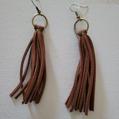 two pairs of brown leather tassels hanging from hooks