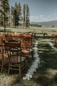 rows of wooden chairs sitting on top of a grass covered field