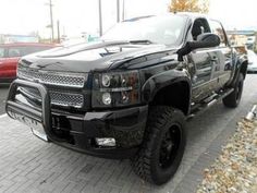 a large black truck parked in a parking lot