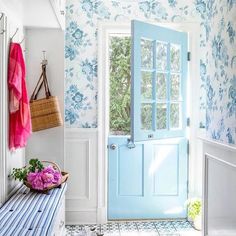 a blue and white entryway with flowers on the bench