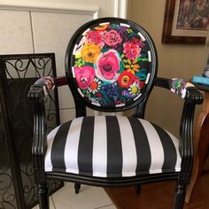 a black and white striped chair with flowers painted on it's armrests