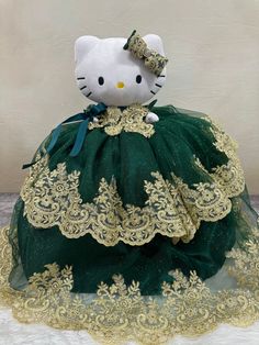 a hello kitty doll in a green dress with gold lace and bows on it's head