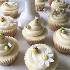 cupcakes decorated with white frosting and yellow bee decorations