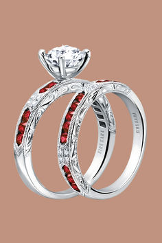 two wedding rings with red and white stones on top of each other, set in 18k white gold