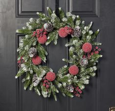 a christmas wreath with pine cones and berries