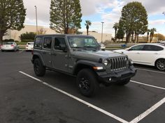 a gray jeep is parked in a parking lot