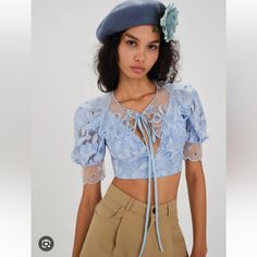 Spring Blues. Organza Embroidery Detachable Collar Low Neckline Puff Sleeve With Scalloped Trim Invisible Zip Closure Partially Lined Fabric + Care Self: 60%Nylon/37%Cotton/3%Tencel; Lining: 98% Recycled Polyester/2% Spandex Measurements Bust:30” Waist:24” Length:15.5” Blue Lace Tops For Spring, Blue Tops For Summer Wedding, Blue Floral Embroidery Tops For Wedding, Fitted Light Blue Lace Tops, Blue Floral Embroidered Tops For Wedding, Blue Lace Short Sleeve Top, Blue Lace Top With Short Sleeves, Blue Lace Crop Top, Collar Crop Top