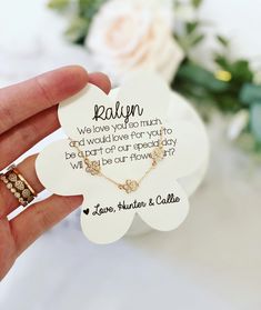 a person holding a white flower shaped brooch in their left hand with a poem written on it