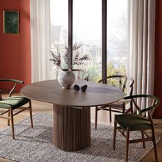 a dining room table with chairs around it and a vase on top of the table