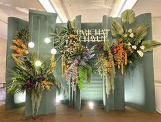 the entrance to an office building decorated with flowers and greenery